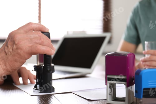 Preview: Senior notary working with clients in office, closeup