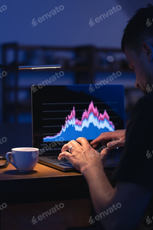 Preview: Broker looking at laptop analyzing stock market invest trading stocks graph.