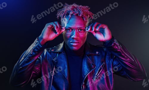 Preview: Having fun. Futuristic neon lighting. Young african american man in the studio