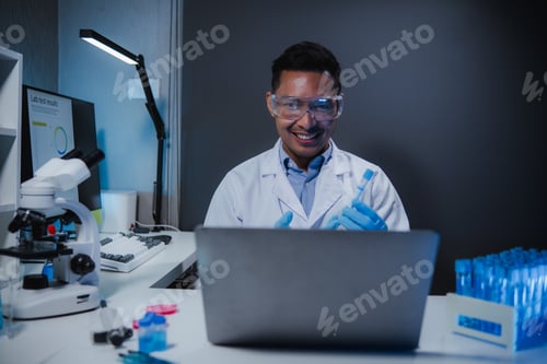 Preview: Research scientist holding test tube during nighttime video conference in medical lab