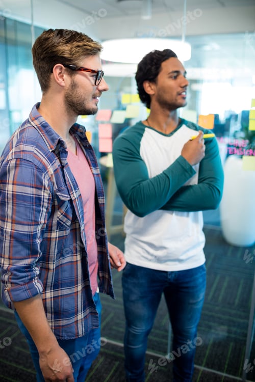 Preview: Creative business team standing against the wall with sticky notes