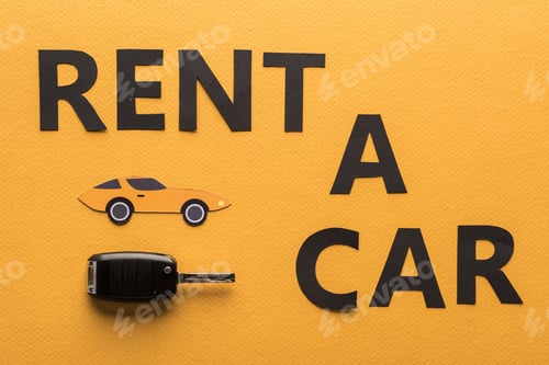 Preview: top view of paper cut rent car lettering and key on orange background