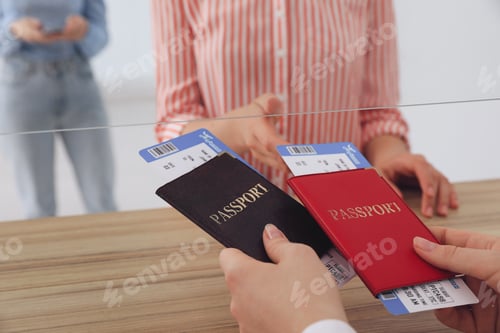 Preview: Agent giving passports with tickets to client at check-in desk in airport, closeup
