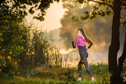 Preview: Female runner running in nature during sunrise