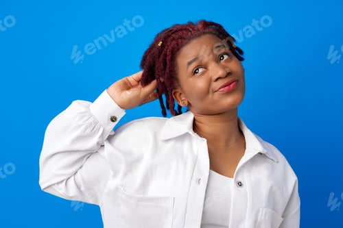 Preview: Thoughtful young african american female portrait against blue background