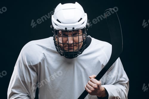 Preview: Handsome hockey player. Smiling at camera isolated on black background.
