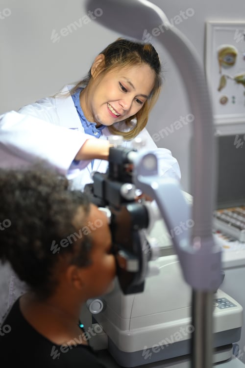 Preview: Young woman ophthalmologist checking eye vision of patient for spectacles glasses.