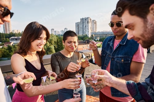 Visualização: joyous multiracial friends with stylish sunglasses drinking tequila with lime and salt at party