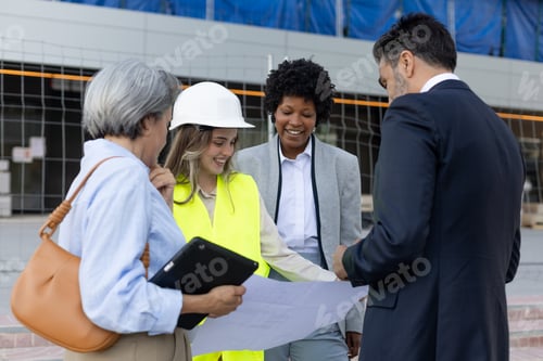 Preview: Architects and engineers discussing blueprint at construction site
