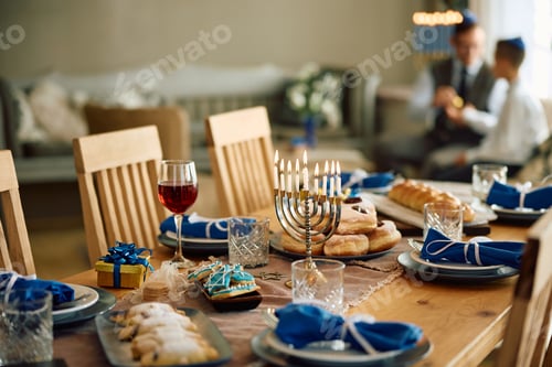 Preview: Hanukkah dining table setting with father and son in the background.