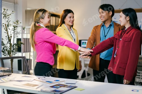 Preview: Diverse group of young asian coworkers celebrating success and showing strong teamwork in the office