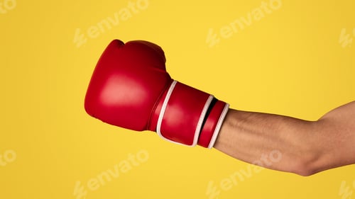 Preview: Closeup of sportsman wearing boxing glove on orange background, panorama