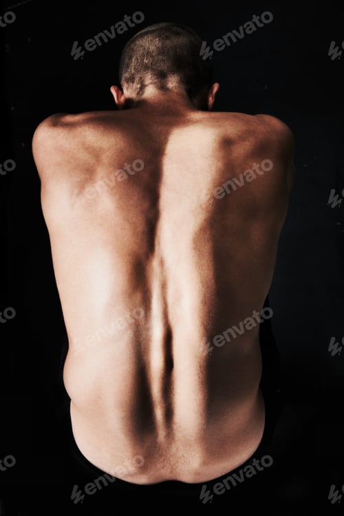 Preview: He just wants to be alone. Top view of a naked man curled into the fetal position.