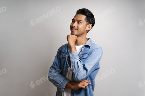 Preview: Asian man crossing arm and looking forward thinking about future.