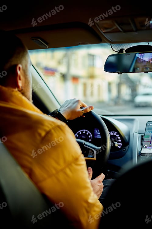 Preview: Concentrated bearded man in casual clothes driving modern car