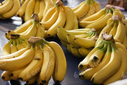 Preview: Bunches of ripe bananas on market stall.