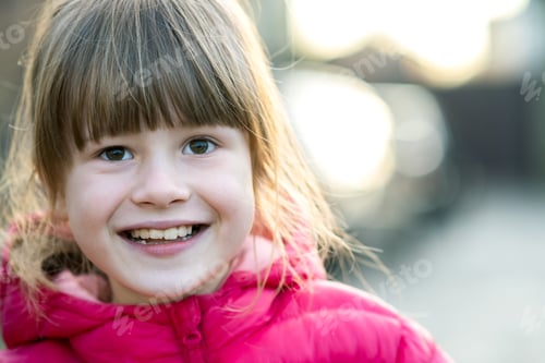Preview: Smiling Girl in Pink Jacket on Blurred Background