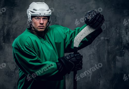 Preview: Hockey player in protective clothes holds playing stick.