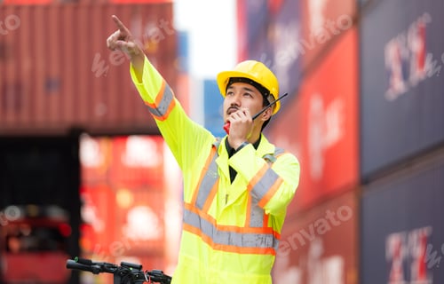 Preview: Portrait of a warehouse worker speaking on a walkie talkie with a coworker