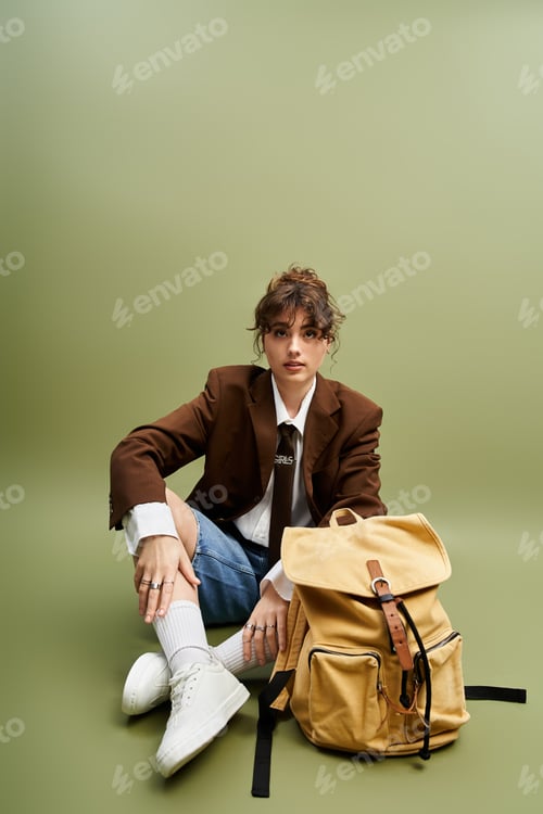 Preview: Young woman showcases trendy style with a chic backpack against a minimalist backdrop