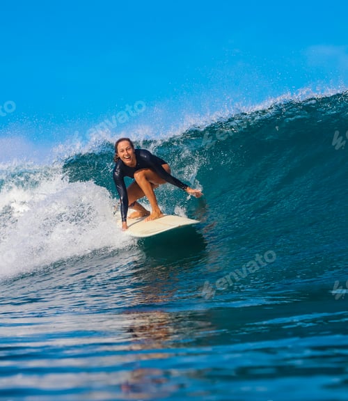 Preview: Female surfer on a blue wave