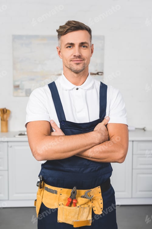 Smiling Repairman Wearing Bib Overalls Arms Crossed Portrait