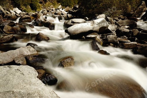 Preview: Fast flowing river stream of water coming down from the mountains passing by big rocks on the