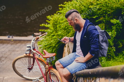 Preview: Male in a park talks by smart phone.