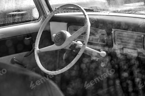Preview: Grey scale close up shot of a vintage car wheel with its windows covered in raindrops