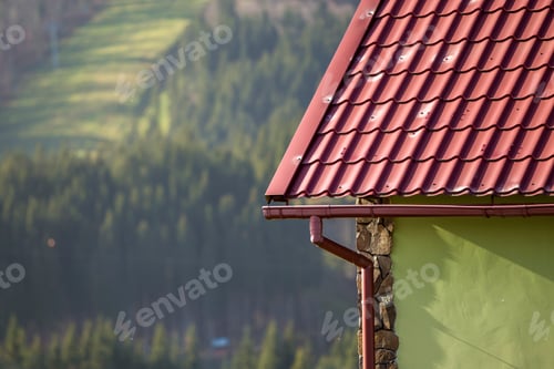 Preview: Detail of new modern house cottage corner with stucco walls decorated with natural stones, red