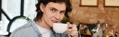 Preview: Handsome young man enjoying a warm beverage in a cozy cafe setting during a leisurely afternoon