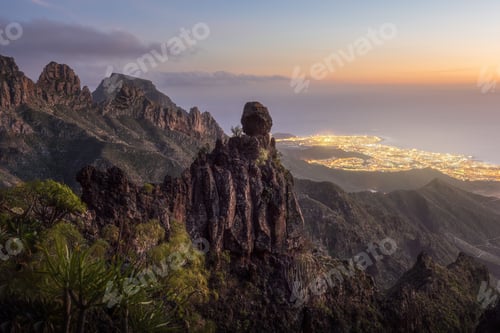 Preview: Panoramic view of the majestic mountains during dusk and Adeje town at the bottom covered with light