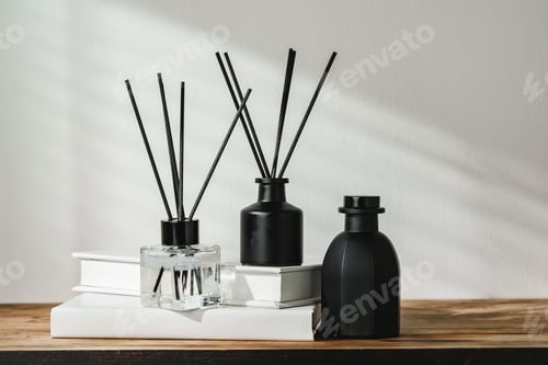 Preview: Aromatic Reed Diffuser on White Books With Shadows Playing on the Wall