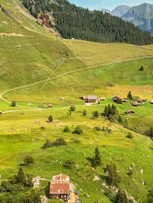 Preview: Swiss alpine chalets in the mountains in Switzerland. Beautiful green mountain summer landscape.