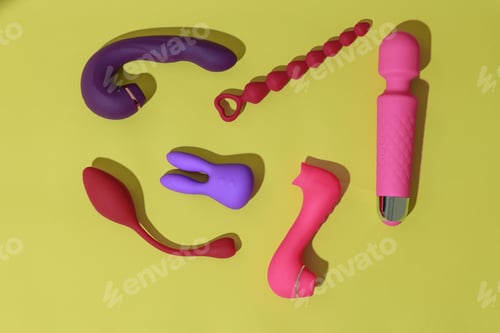 Preview: Top view of adult sex toys such as dildo, vibrator, buttplug on yellow background. Sex