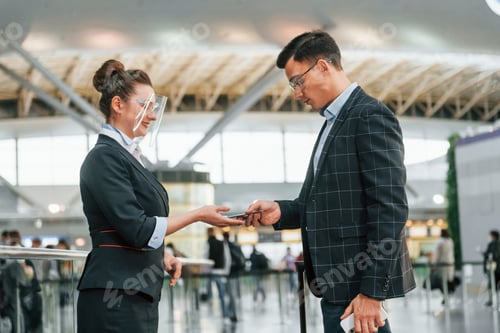 Preview: Working with documents. Young businessman in formal clothes is in the airport at daytime