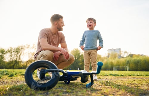 Preview: Little bicycle. Happy father with son are having fun on the field at summertime