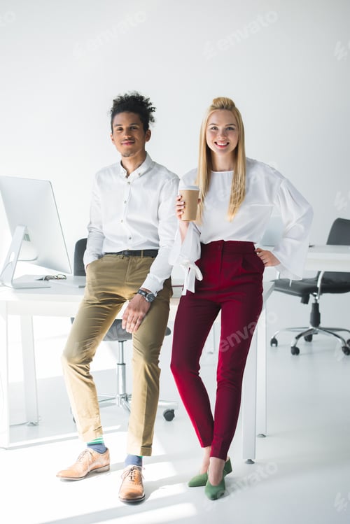 Preview: full length view of young multiethnic business colleagues smiling at camera while standing together