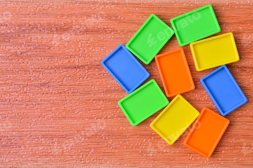 Preview: Colorful plastic blocks isolated on a wooden background