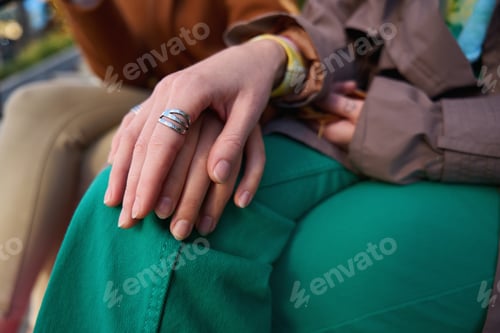 Preview: Couple of young women in youth clothes hold hands