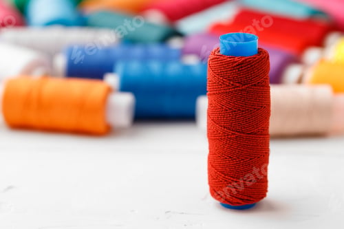 Preview: Colorful sewing accessories on white wooden table
