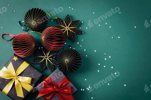 Preview: Paper honeycomb Christmas balls and gift boxes on dark green background with confetti. Christmas