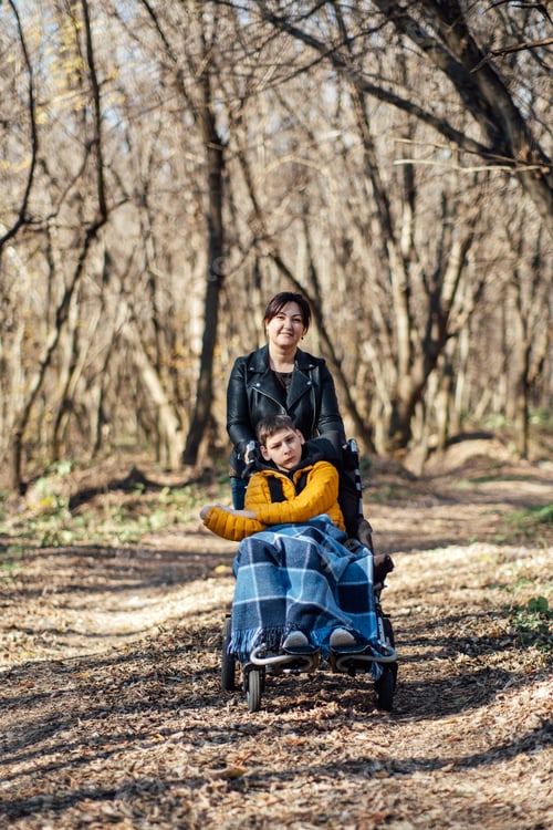 Preview: Mother and child with special needs on forest walk, nature therapy, disability inclusion, family