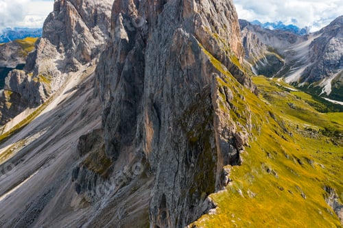 Preview: Rocky Seceda mountain range slope covered with green grass