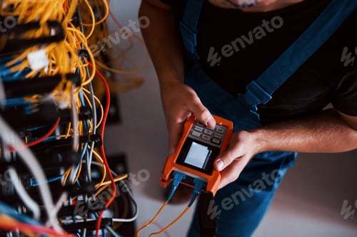 Preview: Young man in uniform works in server room
