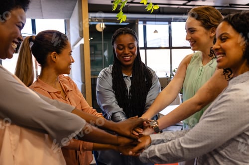Preview: Happy diverse casual businesswomen holding hands in office