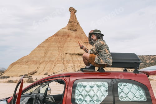 Preview: Man looking at cell phone in desert landscape of Bardenas Reales, Arguedas, Navarra, Spain