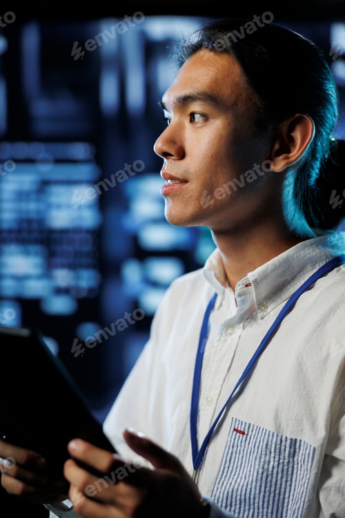Young Man Holding Tablet in Data Center