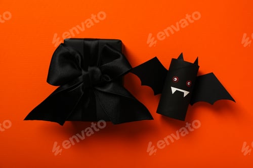 Preview: Gift box and paper bat mockup on orange background, top view