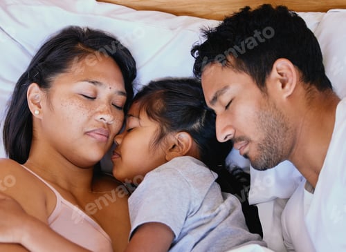 Preview: Mixed race family, mother, father and daughter resting on the white bed in the bedroom at home. Tir